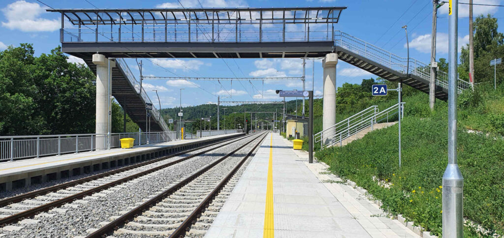 Vlaková zastávka v Omicích s charakteristickou lávkou nad tratí.