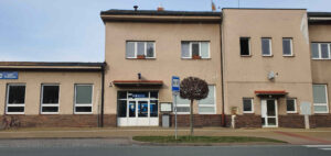 Hlavní vstup na nádraží v Chlumci nad Cidlinou. Za dveřmi je průchozí čekárna s pokladnami.