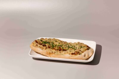 Jihotyrolský plochý chléb pinsa s hruškou, sýrem a uzenou slaninou