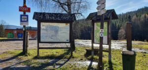 Turistický rozcestník před nádražím v Kořenově